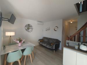 a living room with a couch and a table and chairs at Côté Marina in Gruissan