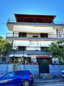 a blue car parked in front of a building at Alex Apartments in Sarandë