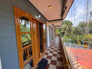 a house with a checkered floor and a door at Sukhavana home stay suite in Madikeri