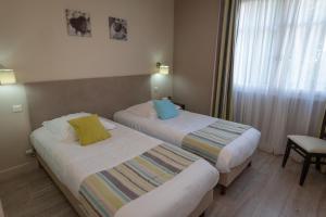 Postel nebo postele na pokoji v ubytování Logis Hotel La Croix du Sud + 5 fotografií