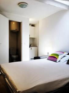 1 dormitorio con 1 cama blanca grande con almohadas coloridas en Les Halles Appartements en París