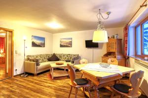 a living room with a couch and a table at Haus Alpenblick in Oberjoch