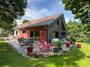une maison avec un patio avec une table et des chaises dans l'établissement LES ANTHOCYANES CHAMBRE MONTAGNE, à Champagny