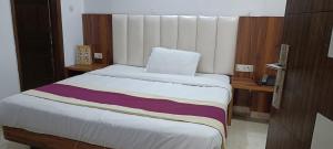 a bedroom with a bed with a striped blanket on it at Hotel Leo in New Delhi