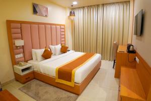a bedroom with a large bed and a television at Hotel Cheer Royale in Bareilly