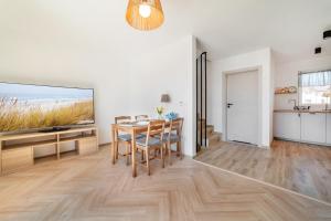 a dining room with a table and a large screen tv at Sztormowa 7 in Jastarnia