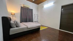 a small bedroom with a bed with a window at PJ Homestay in Bayan Lepas +5 photos