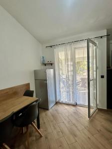 a kitchen with a refrigerator and a table and a window at Apartmani Kim in Starigrad