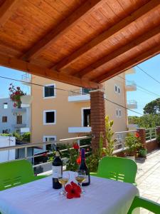 a table with two bottles of wine on a patio at Arlind's Apartaments in Vlorë