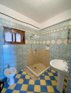 a bathroom with a sink and a shower and a toilet at Arlind's Apartaments in Vlorë