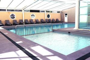 a swimming pool with chairs in a building at Camping les Alouettes - Bretignolles-sur-Mer in Bretignolles-sur-Mer
