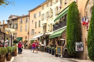 a group of people walking down a street with buildings at Cannes, Mougins, Sophia-Antipolis, Grasse, Nice, Monaco, Saint-Tropez in Mougins