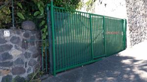 a green gate on the side of a stone wall at T2 de 70m2 avec terrasse en rez de jardin in La Possession