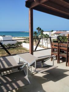 a table and bench on a balcony overlooking the beach at Boadream Ca' Madeira 1 Attico Linea Prestige in Sal Rei