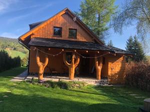 une cabane en rondins avec des troncs d'arbres devant elle dans l'établissement Chata pri potoku, à Hruštín