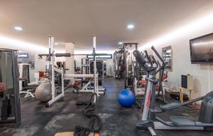 a gym with several tread machines and a television at Casa Per in Marbella