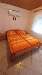 a wooden bed in a room with a window at Fenyves Villa in Balatonfenyves