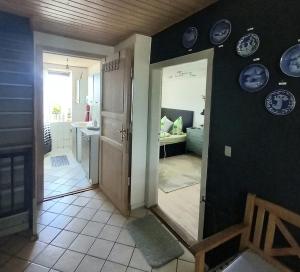a room with a hallway with a door and plates on the wall at LilleLandsted Knechtekammer in Vojens +5 photos