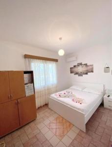 a bedroom with a large white bed in a room at Arlind's Apartaments in Vlorë