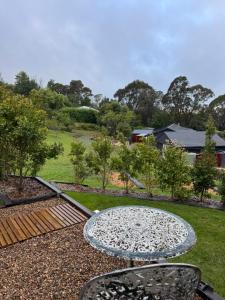 a table and chairs sitting on top of a yard at Painters Studio , Home On the Hill in Bowral +26 photos