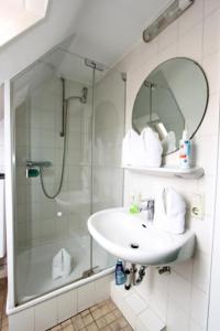 ein Badezimmer mit Waschbecken und Dusche mit Spiegel in der Unterkunft Haus Atlantis "Holzwohnung 3" in Hörnum