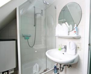 ein Badezimmer mit Waschbecken und Dusche in der Unterkunft Haus Atlantis "Holzwohnung 3" in Hörnum