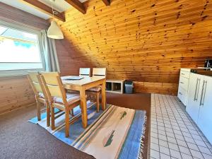eine Küche mit Tisch und Stühlen in einem Zimmer in der Unterkunft Haus Atlantis "Holzwohnung 3" in Hörnum + 2 Fotos