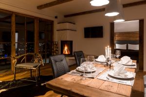 una sala da pranzo con tavolo, sedie e camino di Das Chalet a Schladming