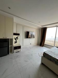 a large white room with a bed and a television at Effile view studio apartment in Lahore
