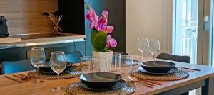 a table with plates and glasses and flowers on it at Orelli House - TriLocal Superior in Lissone