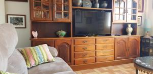 un salon avec un grand centre de divertissement avec une télévision dans l'établissement Ático en Cimadevilla Mirando al Mar, à Gijón