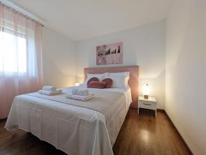 une chambre blanche avec un lit avec des serviettes dessus dans l'établissement Seaside Serenity "Rose" with pool, 150m from sea, à Sukošan 23 autres photos