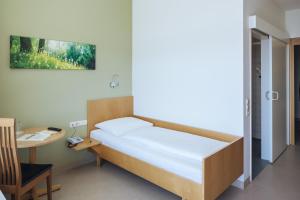 una camera da letto con un letto, una scrivania e un tavolo di Hotel Viktor a Viktorsberg Altre 29 foto