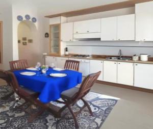 a kitchen with a blue table and chairs in a kitchen at Casa Platamone 2 in San Vito lo Capo