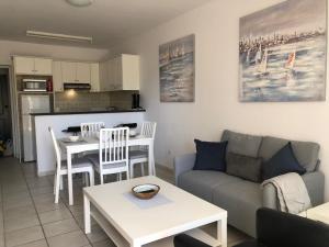 a living room with a couch and a table at Stylish 1BR Apt With Pool - Near Mall, Restaurants & Shops in Paphos