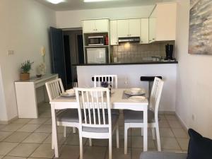 a kitchen and dining room with a table and chairs at Stylish 1BR Apt With Pool - Near Mall, Restaurants & Shops in Paphos