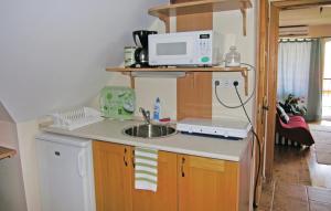 a kitchen with a sink and a microwave on a counter at Pelso apartman in Balatonalmádi