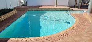 a swimming pool with a hose in the water at Martha's Guesthouse in Gqeberha
