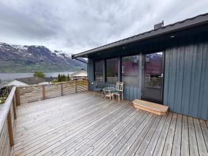a house with a deck with a table and a bench at House near Odda, Dronningstien and Trolltunga in Hovland