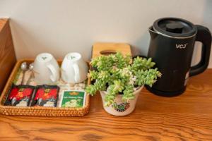 a table with two vases and a coffee pot and a plant at Agarwood Hotel in Ha Long