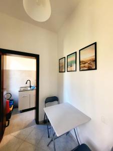 Una habitación con una mesa blanca y un lavabo. en Casa Siria, en Livorno