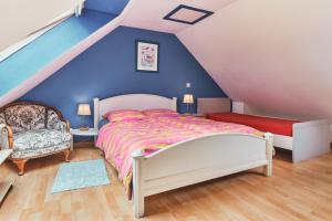 a bedroom with a bed and a blue wall at Cottage Batz - Moulin de Kerellec in Plougoulm