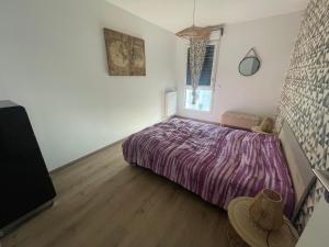 a bedroom with a bed with a purple blanket at Appartement T3 Curistes in Dax
