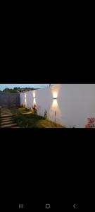 due luci sul lato di un edificio vicino a un lago di فيلا فاخرة a Imouzzer Kandar