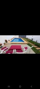 due foto di una piscina con sedie e una piscina di فيلا فاخرة a Imouzzer Kandar