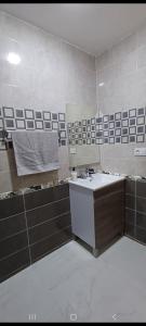 un bagno con lavandino e specchio di فيلا فاخرة a Imouzzer Kandar
