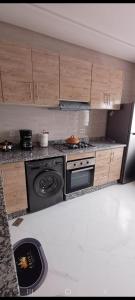una cucina con piano cottura e armadietti in legno di فيلا فاخرة a Imouzzer Kandar