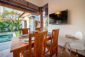ein Esszimmer mit einem Holztisch und Stühlen in der Unterkunft Stylish 3 BR Villa Near Canggu in Canggu