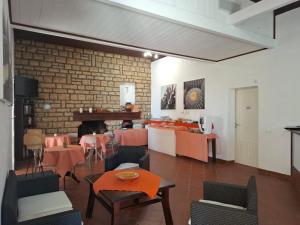 a living room with tables and chairs and a brick wall at Residence Casale Verderame in Trapani