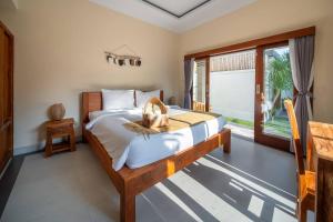 ein Schlafzimmer mit einem Bett und einem großen Fenster in der Unterkunft Stylish 3 BR Villa Near Canggu in Canggu + 17 Fotos